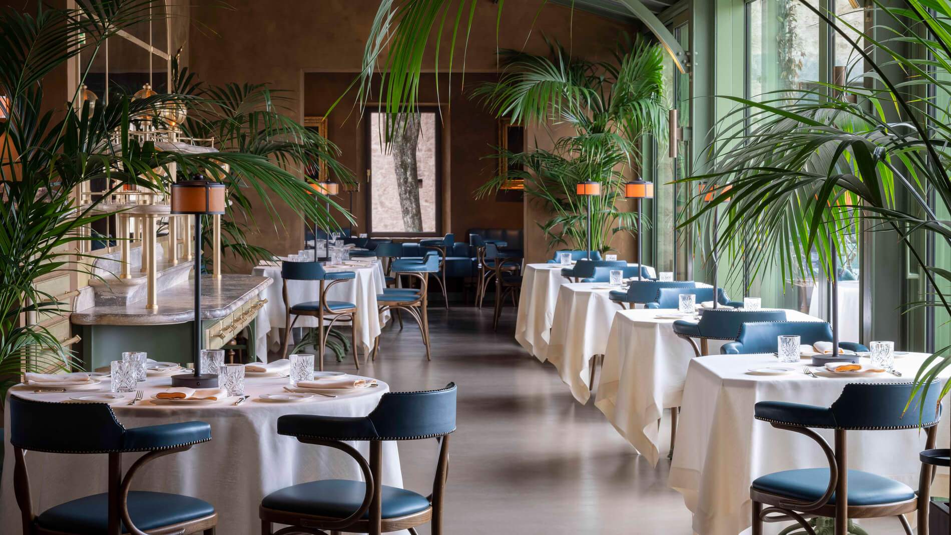 A restaurant with a blue tablecloth and chairs.
