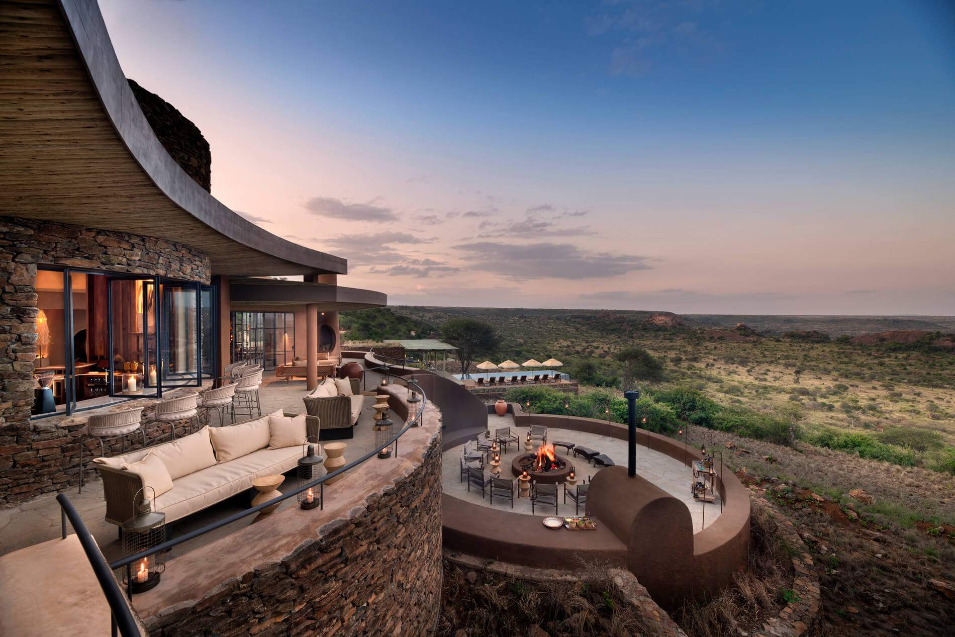 A large stone house with a fire pit and a patio.