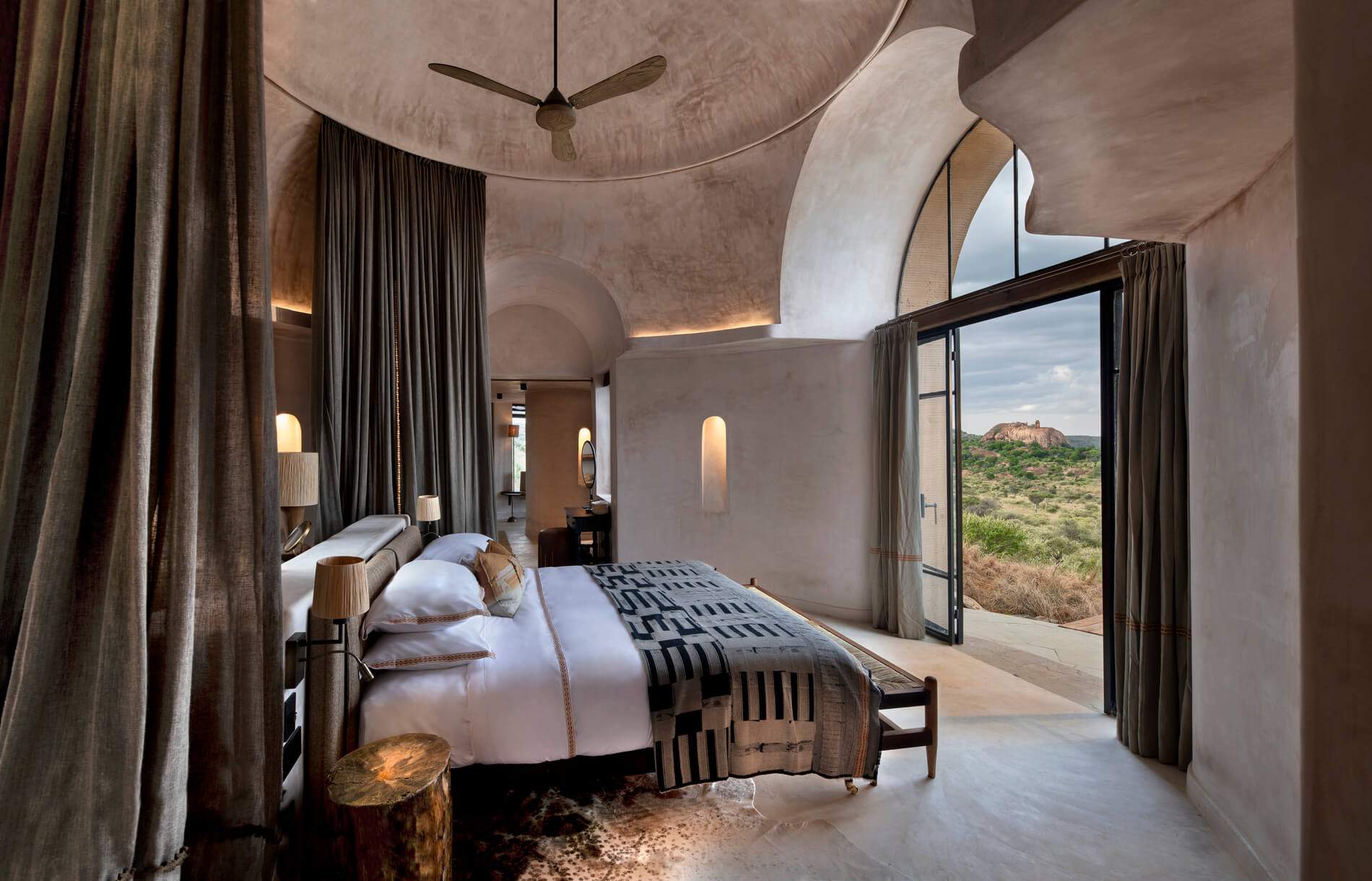 A bedroom with a bed and a lamp.
