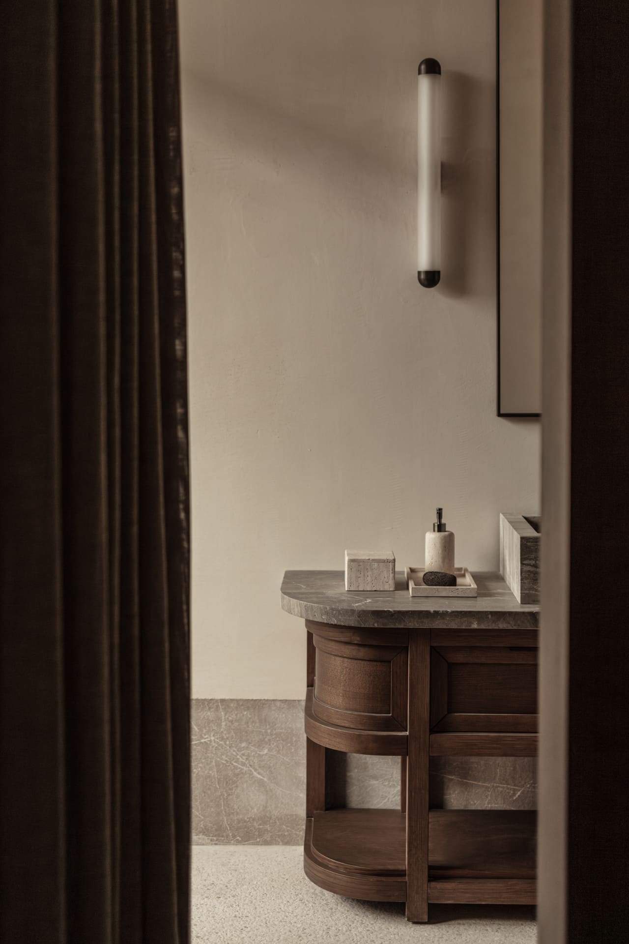 A bathroom counter with a bottle of lotion on it.