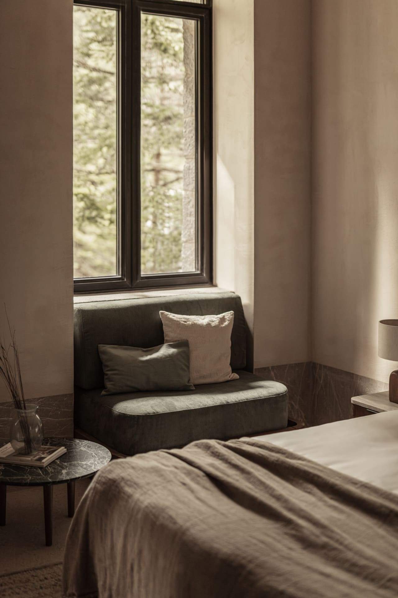 A bedroom with a couch and a window.