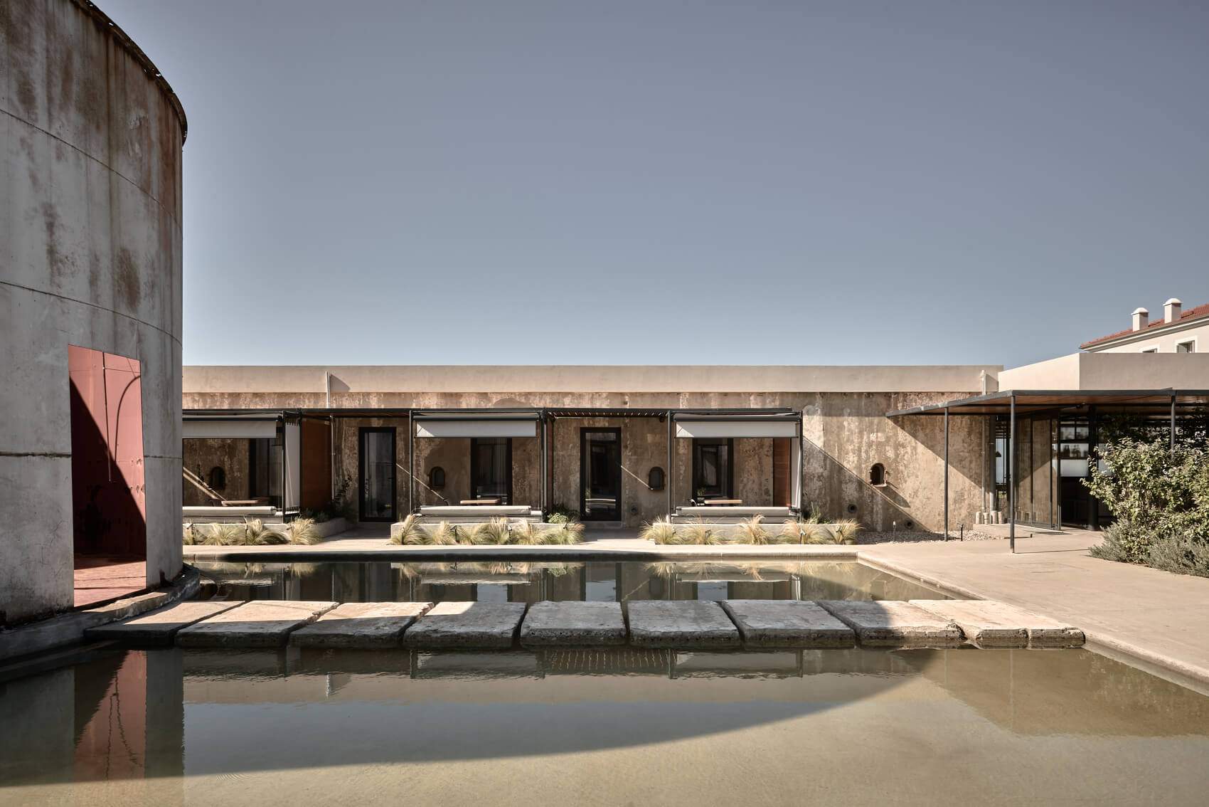 A large building with a pool in front of it.