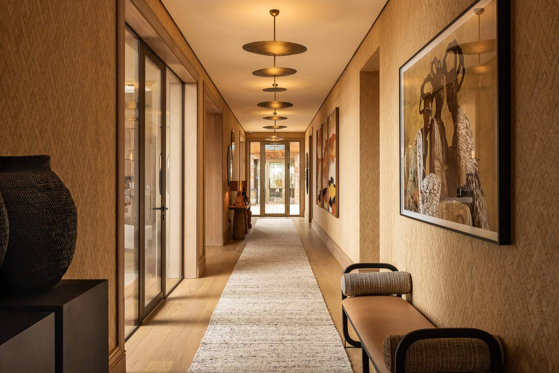A hallway with a rug and a bench.