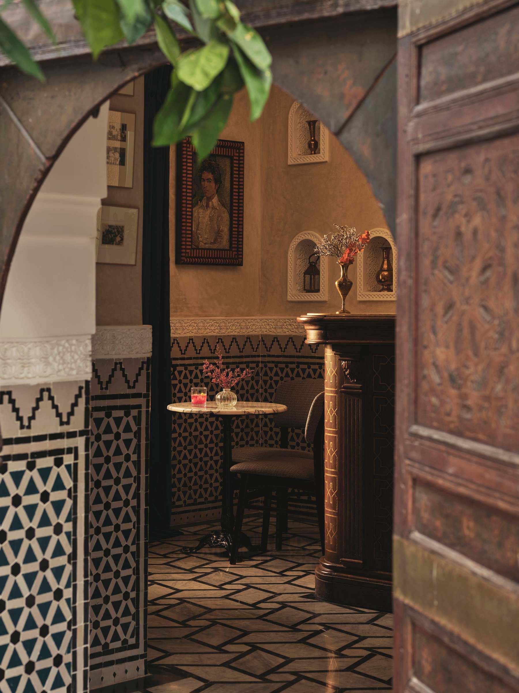 A doorway with a table and chairs in front of a painting.