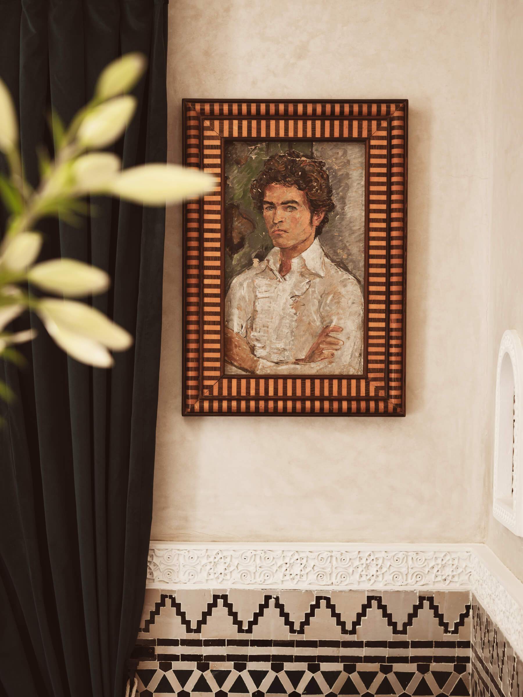 A painting of a man with a mustache is hanging on a wall.