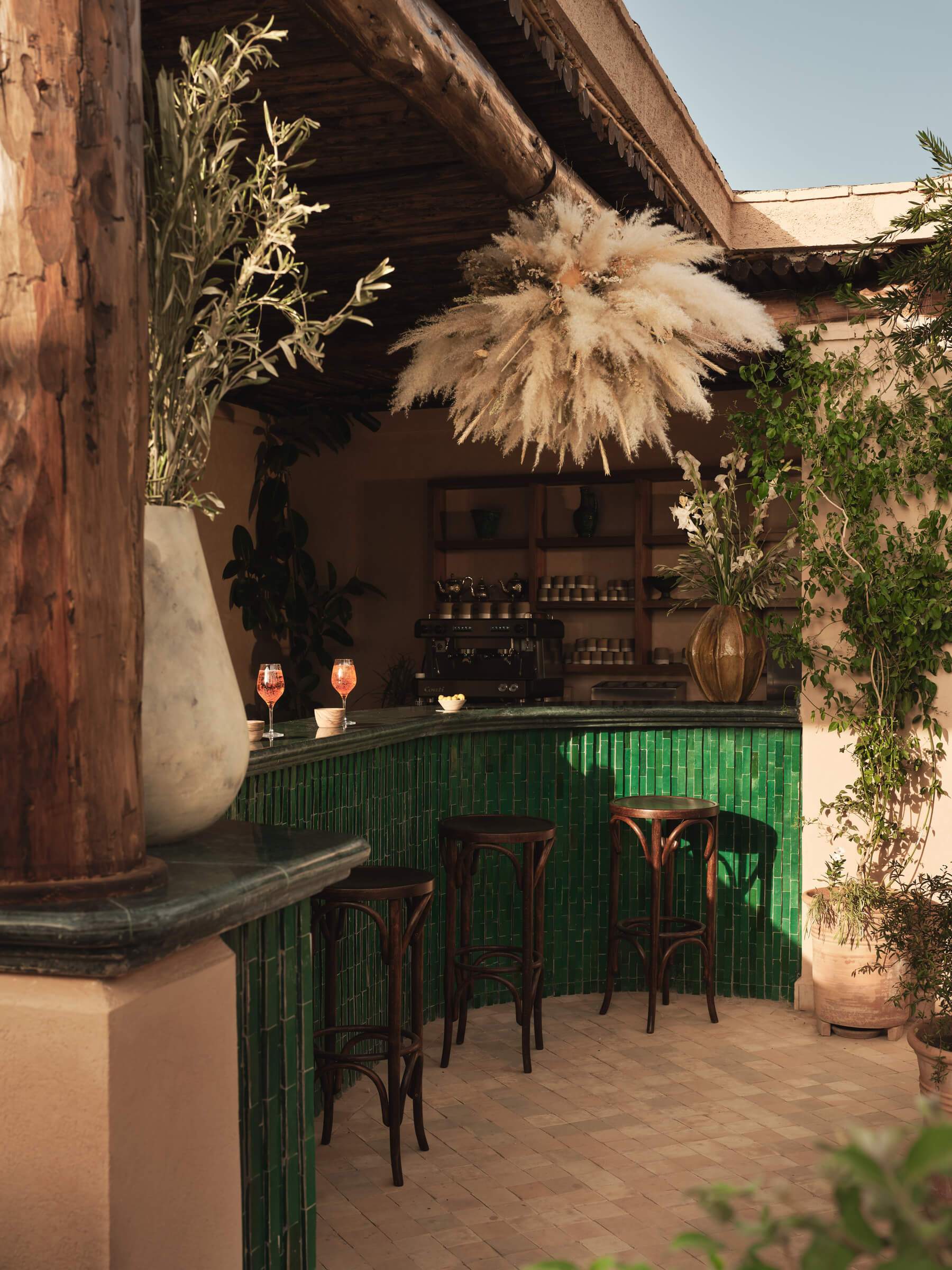 A bar with a green counter top and a hanging plant.