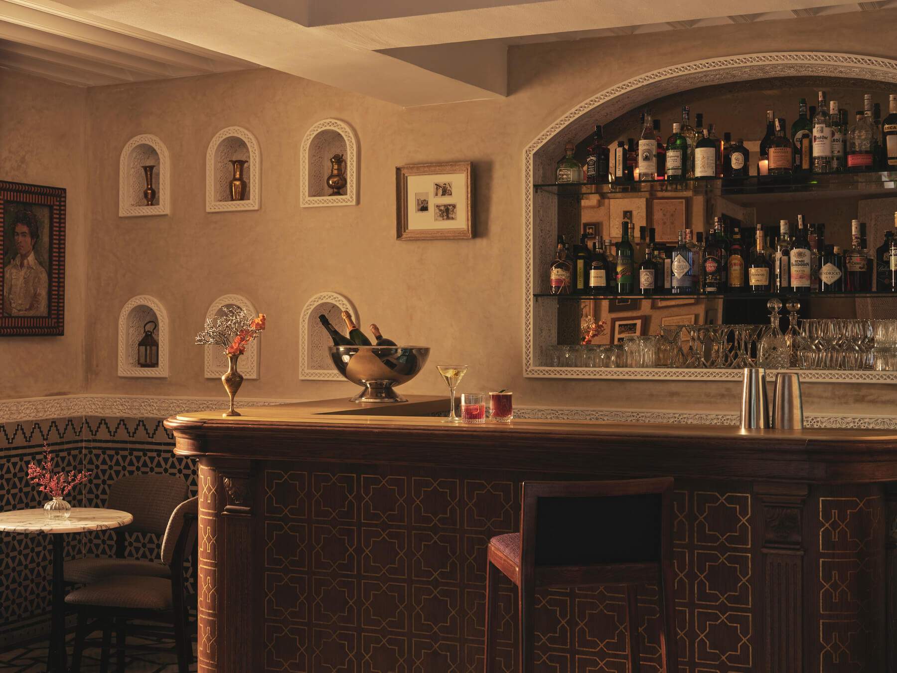 A bar with a large collection of liquor bottles and wine glasses.