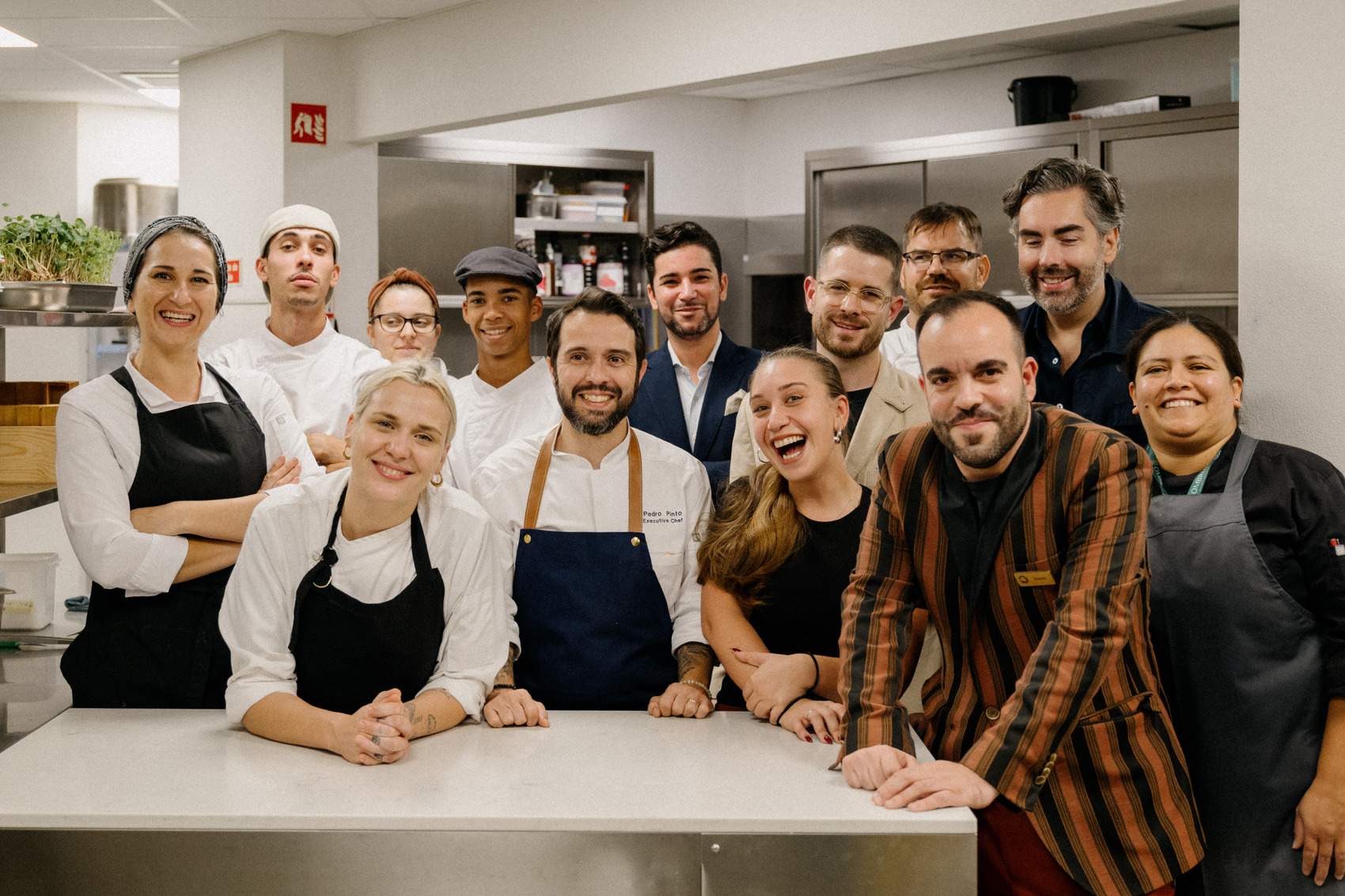 A group of people in a kitchen posing for a picture.
