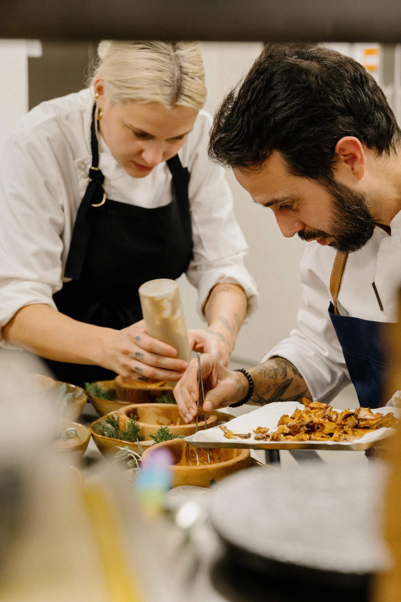 A man and a woman are preparing food in a kitchen.