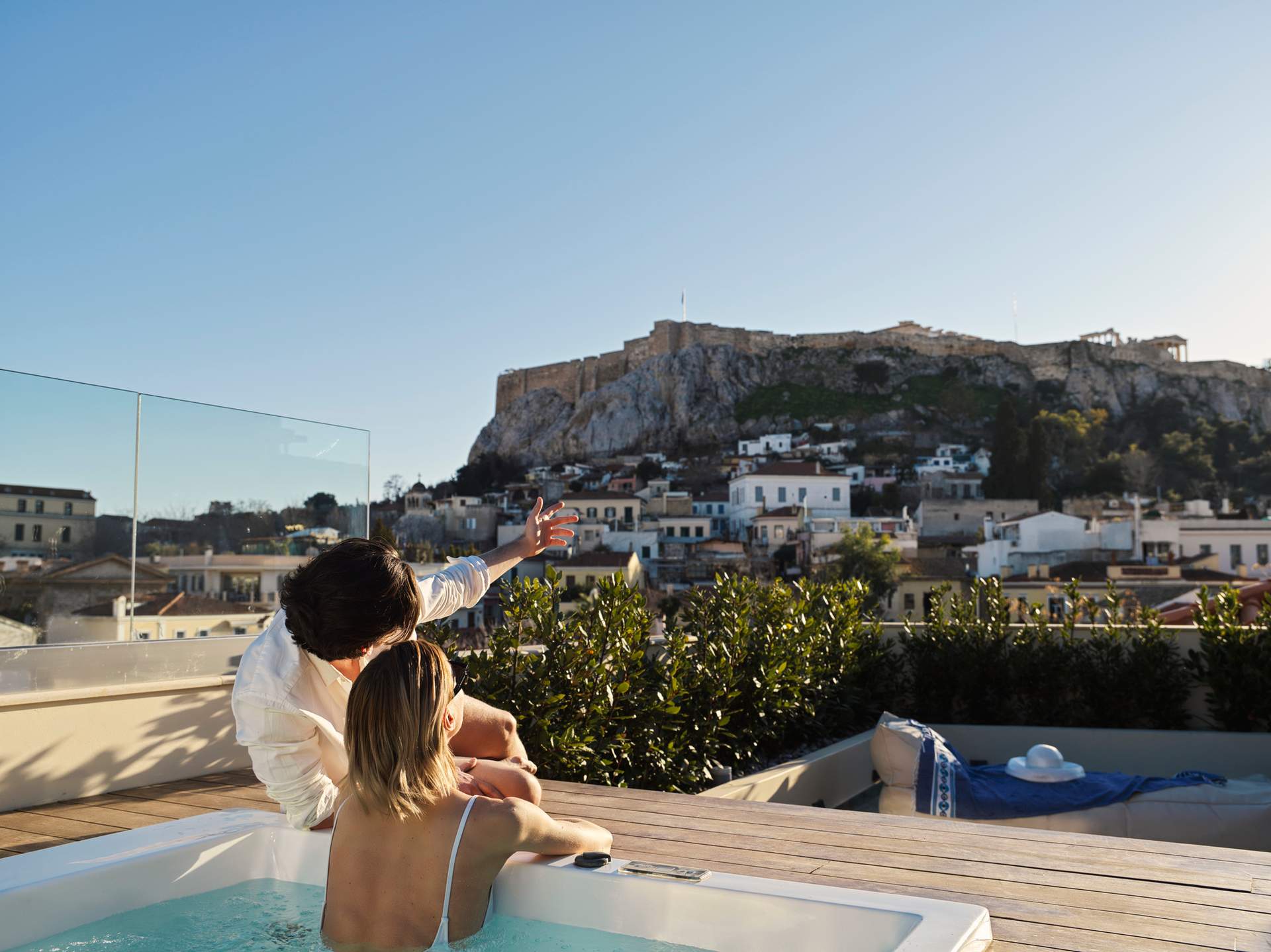 A woman in a white top is sitting in a bathtub.