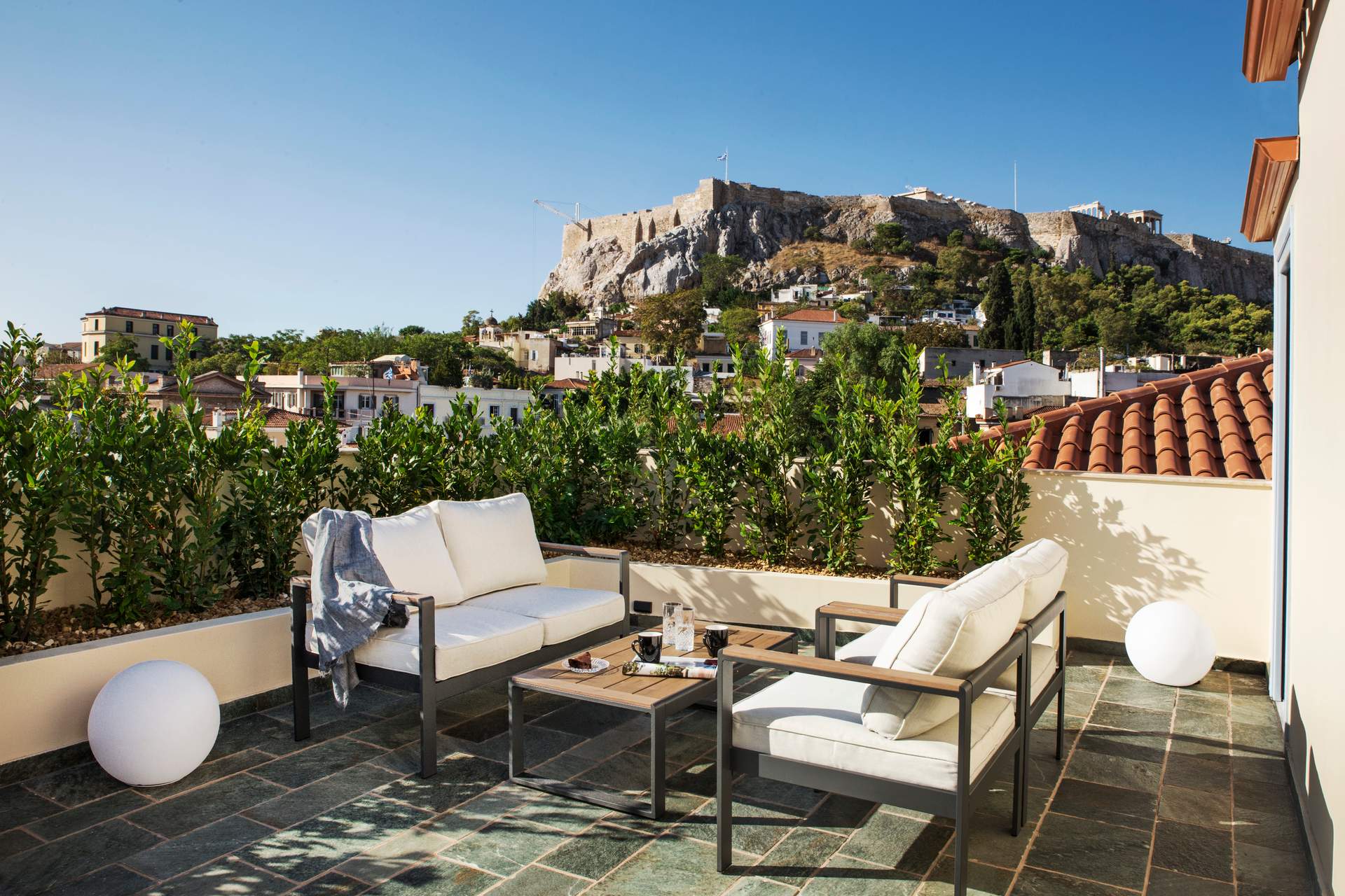 A patio with a table and chairs overlooking a city.