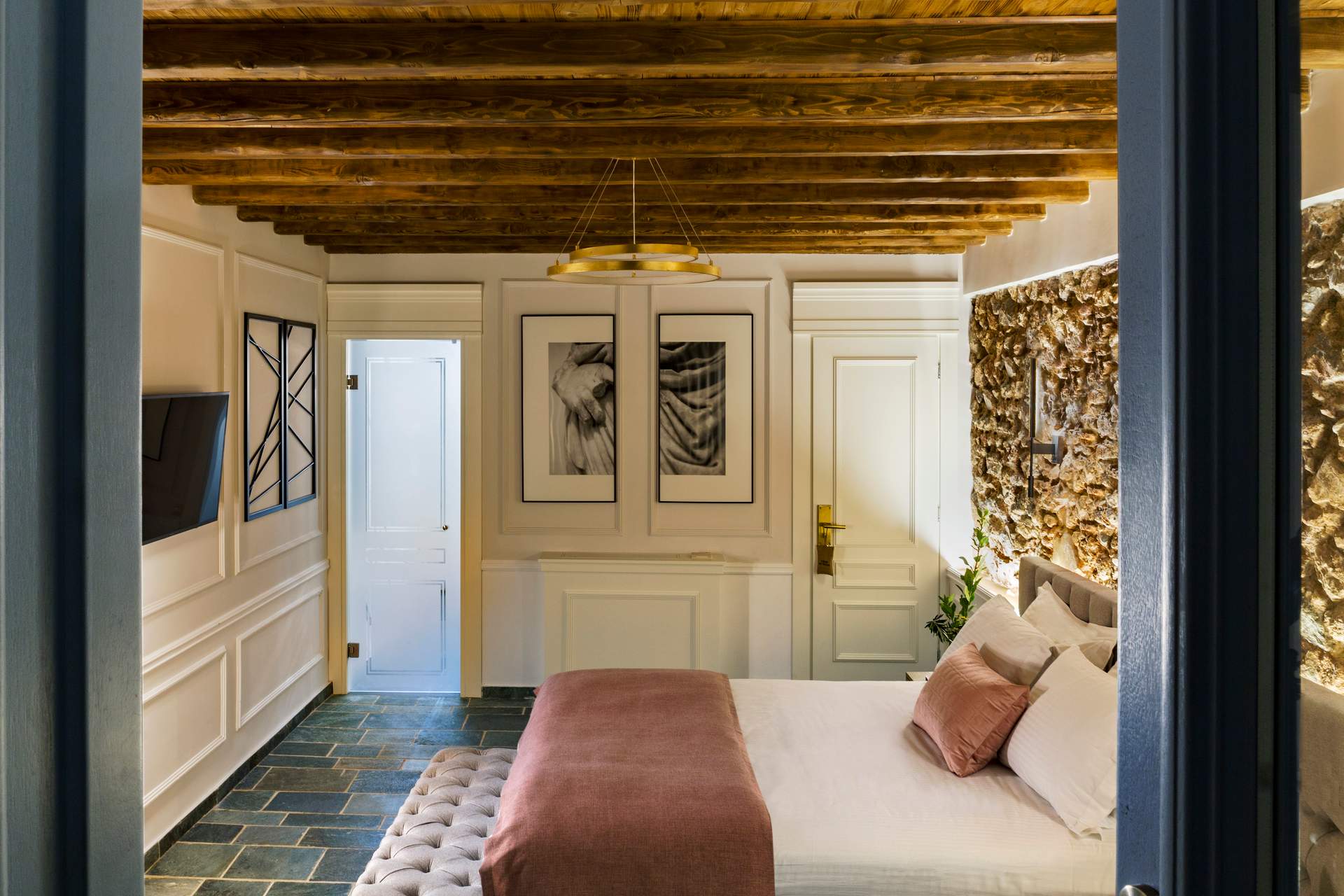 A bedroom with a bed and a picture of a woman on the wall.