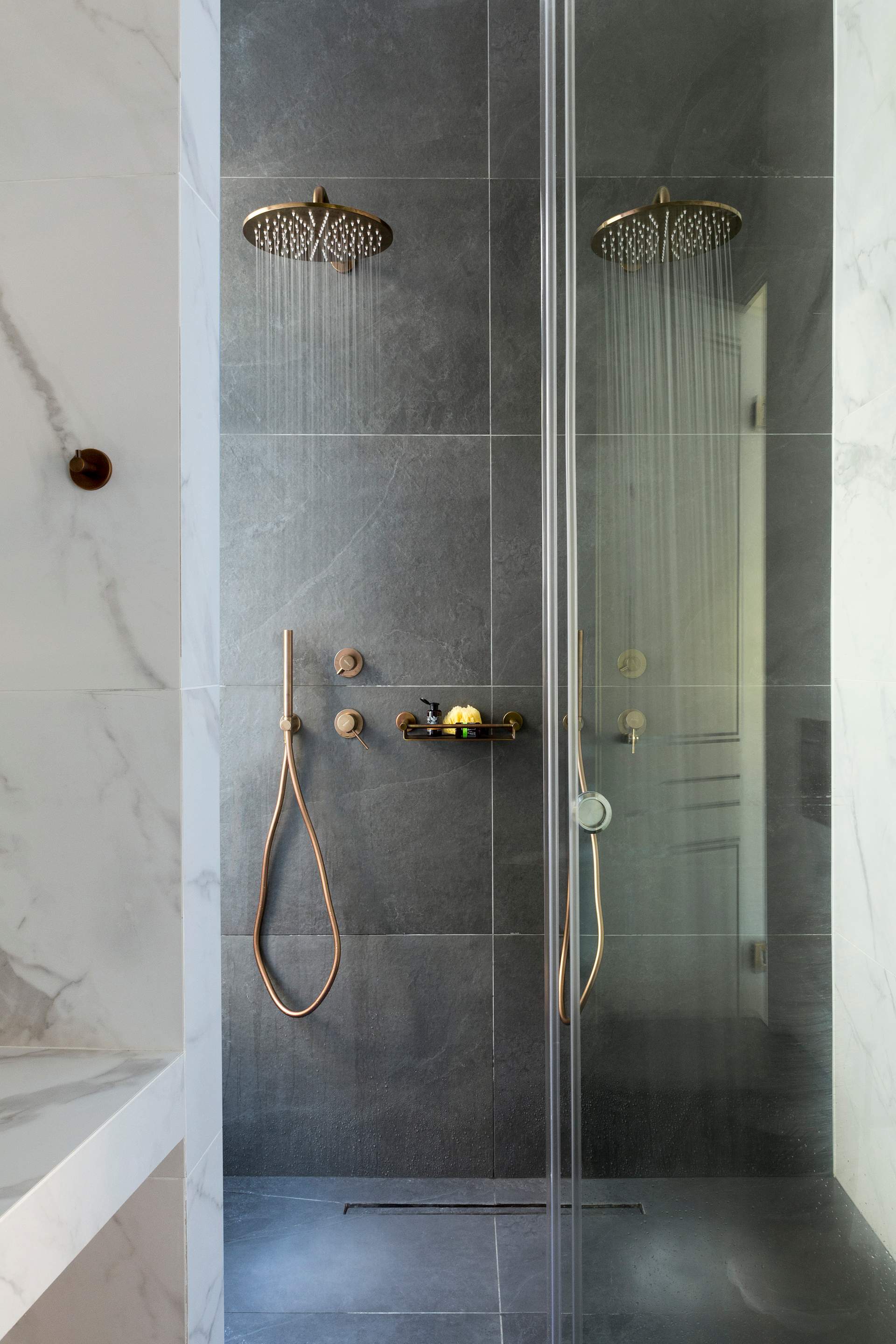A shower with a glass door and a shower head.