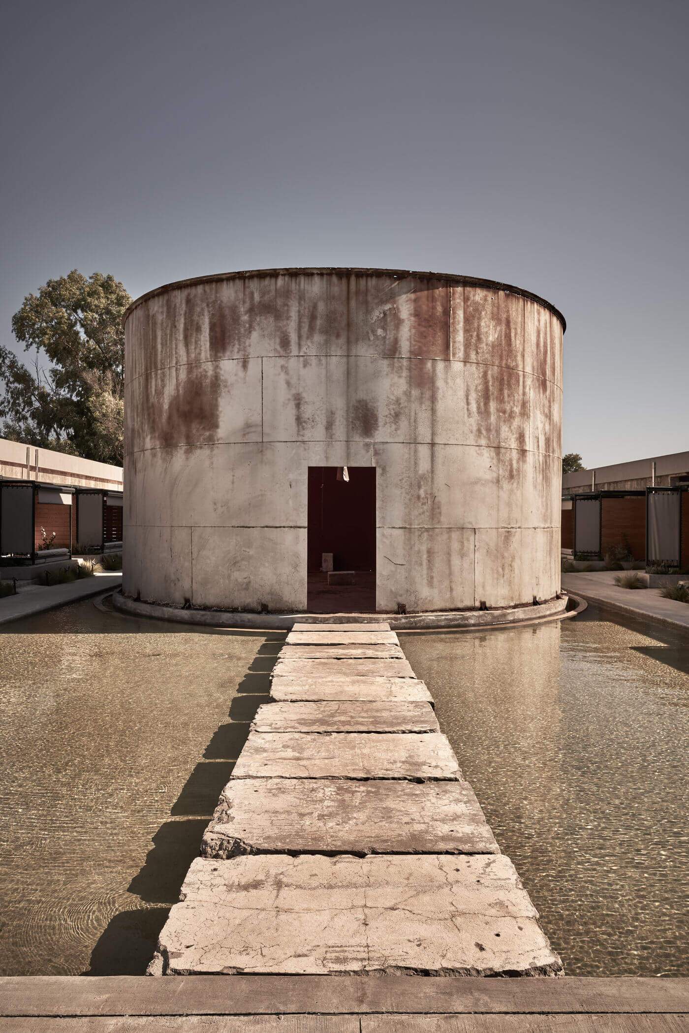 A concrete structure with a red door and a white wall.