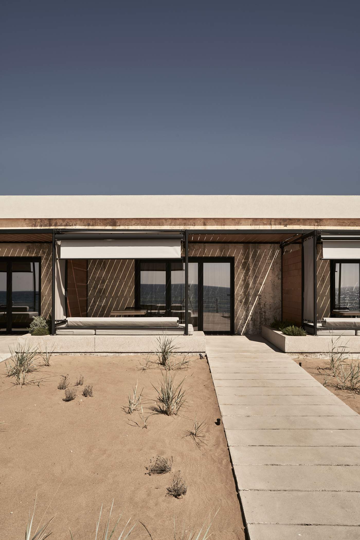 A house with a patio and a view of the ocean.