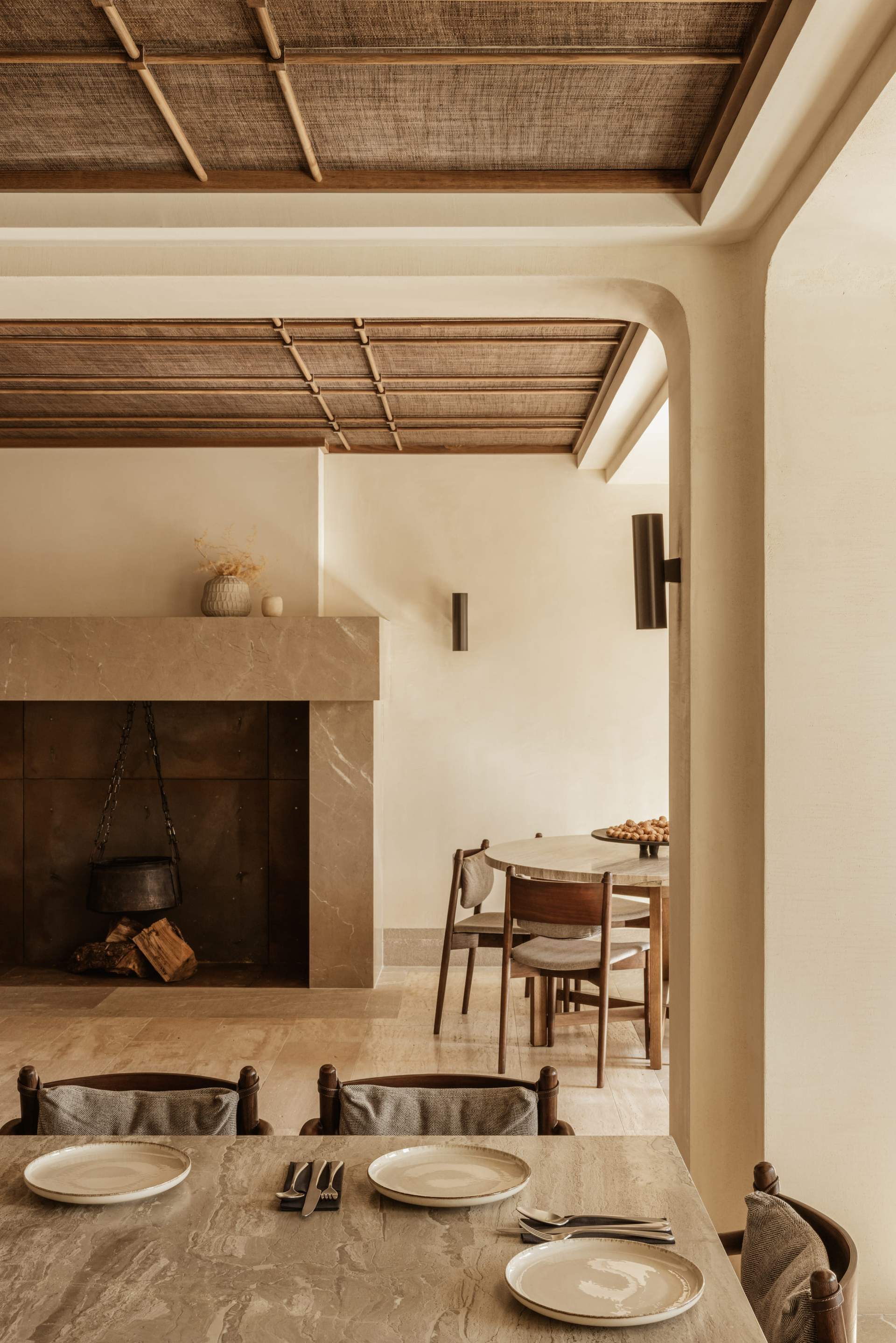 A living room with a fireplace and a table with chairs.