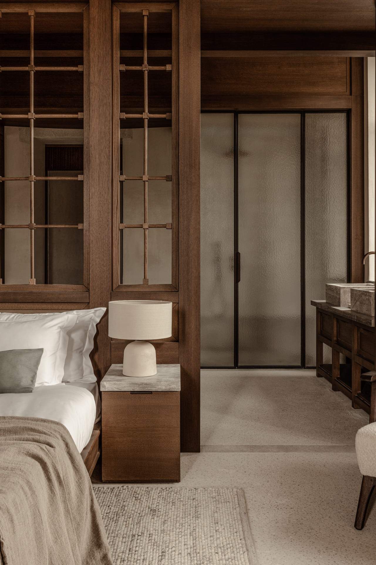 A bedroom with a bed and a lamp.