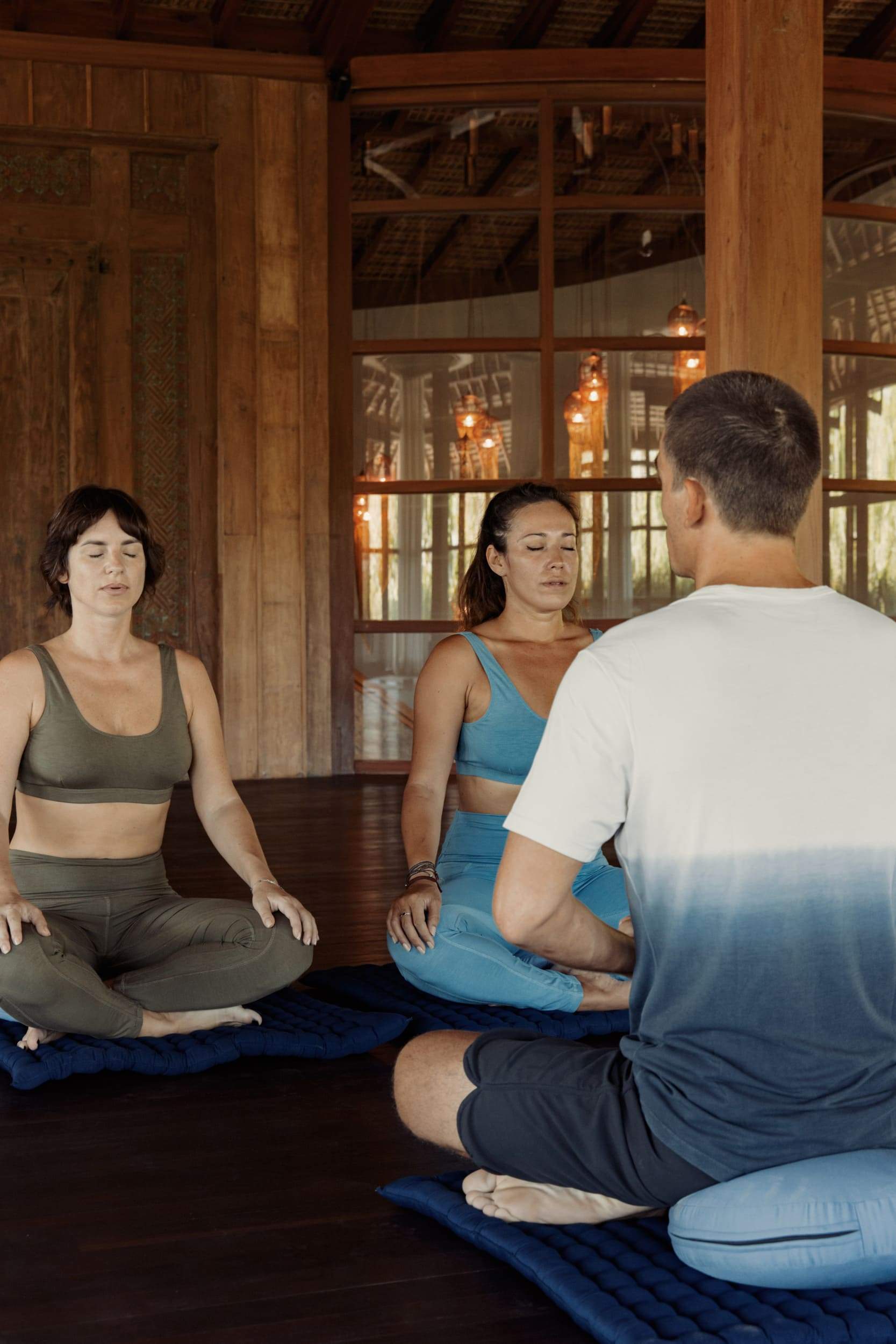 Three people sitting on the floor in a room.