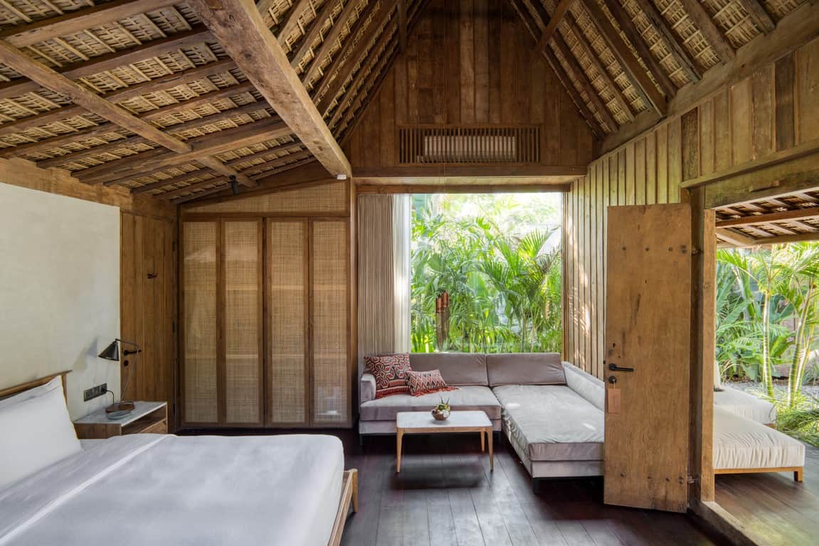 A bedroom with a bed, couch, and table.