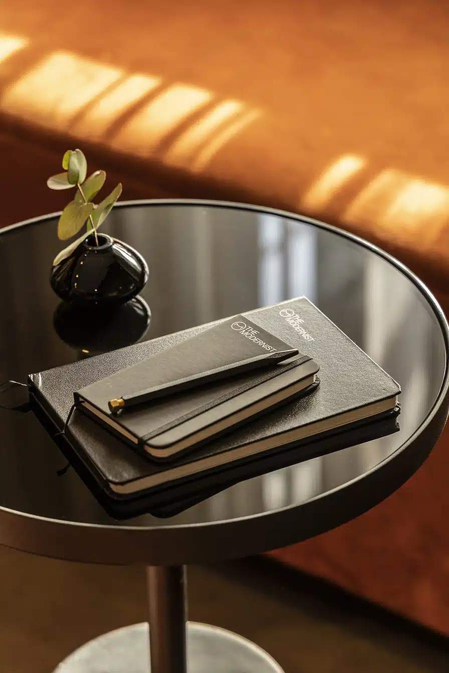 A black notebook with a pen on top of it.