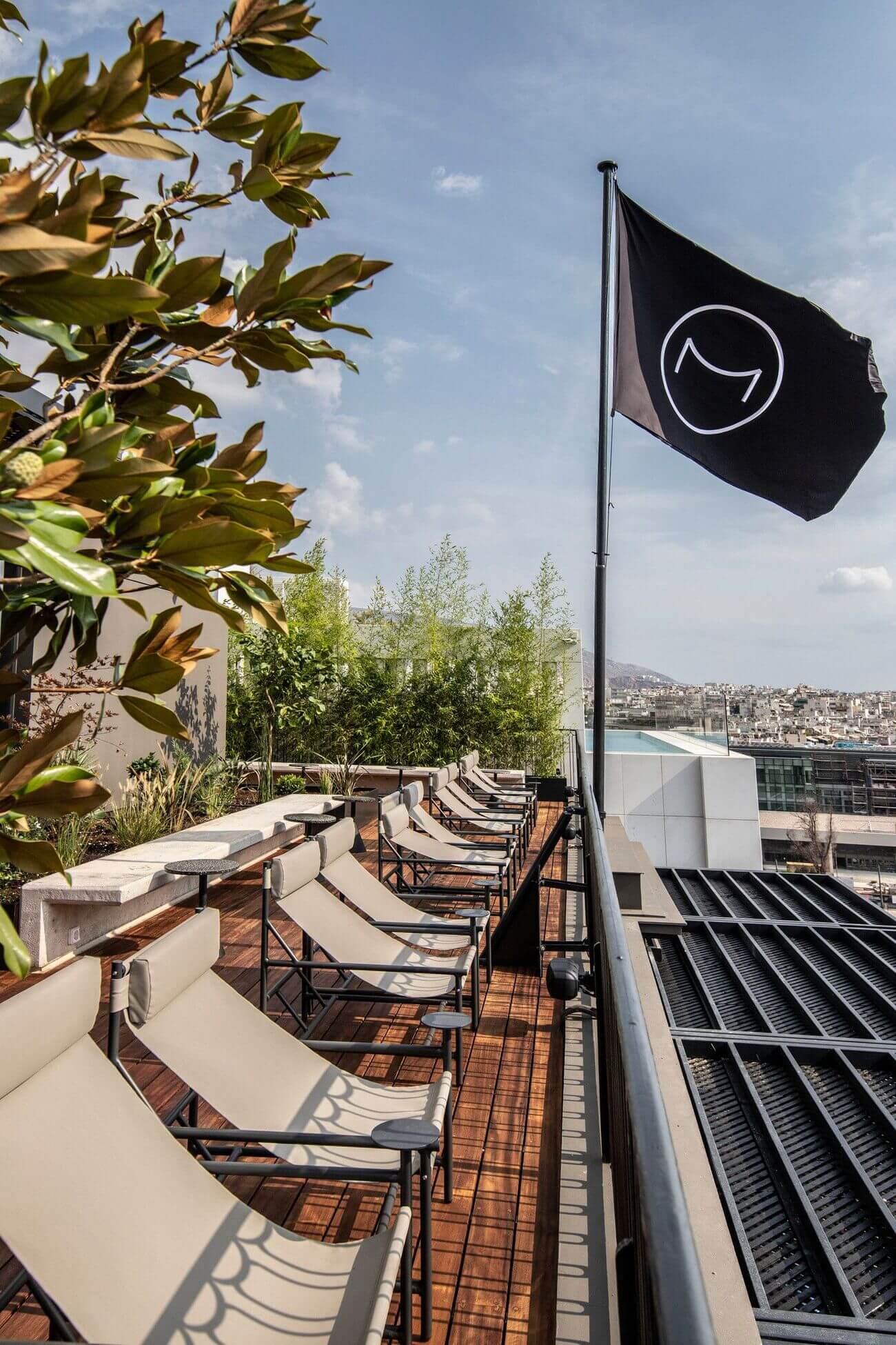 A black and white flag on a wooden pole with a patio set underneath it.