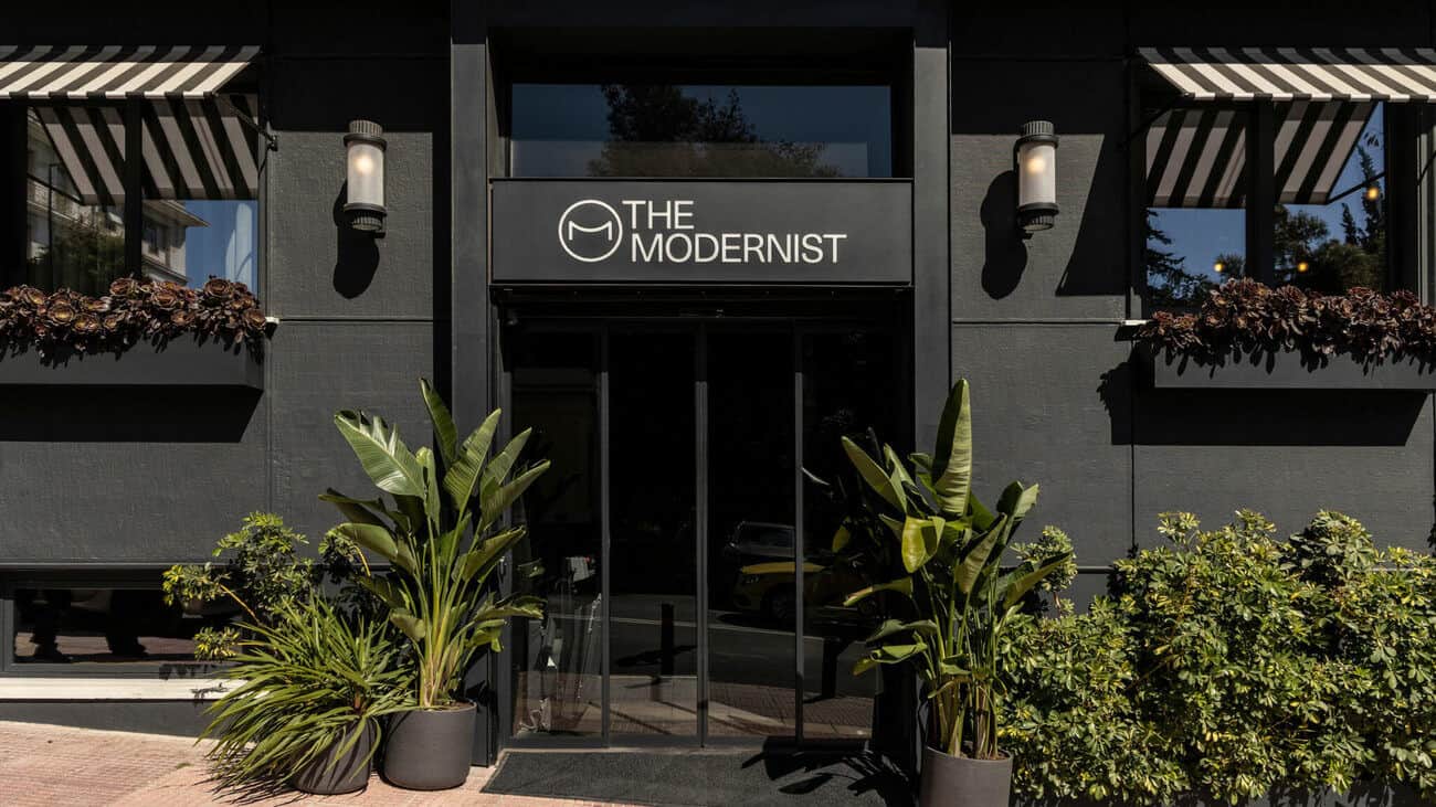 A black and white sign that says "The Modernist" in front of a building.