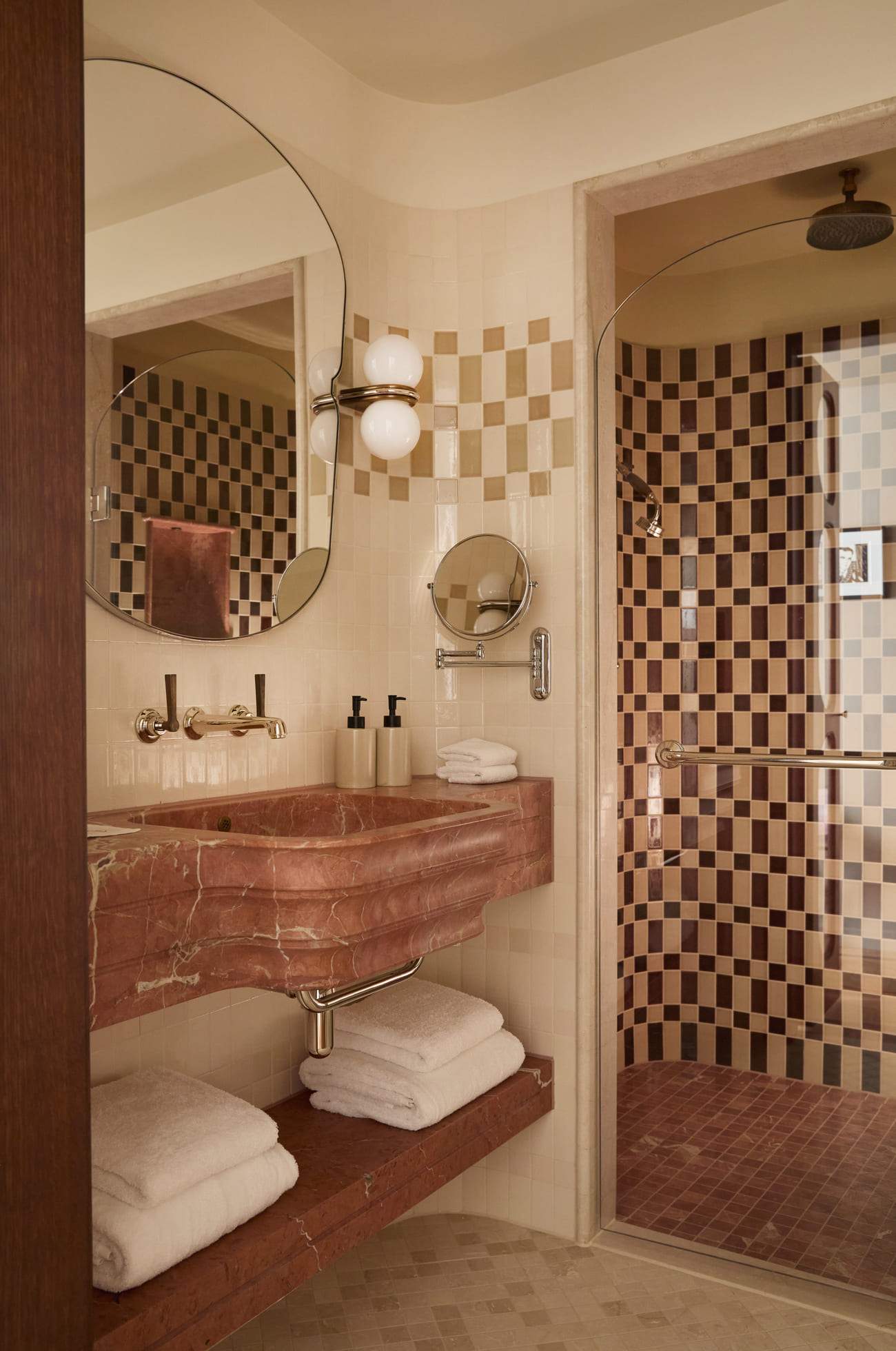 A bathroom with a pink sink and a checkered floor.
