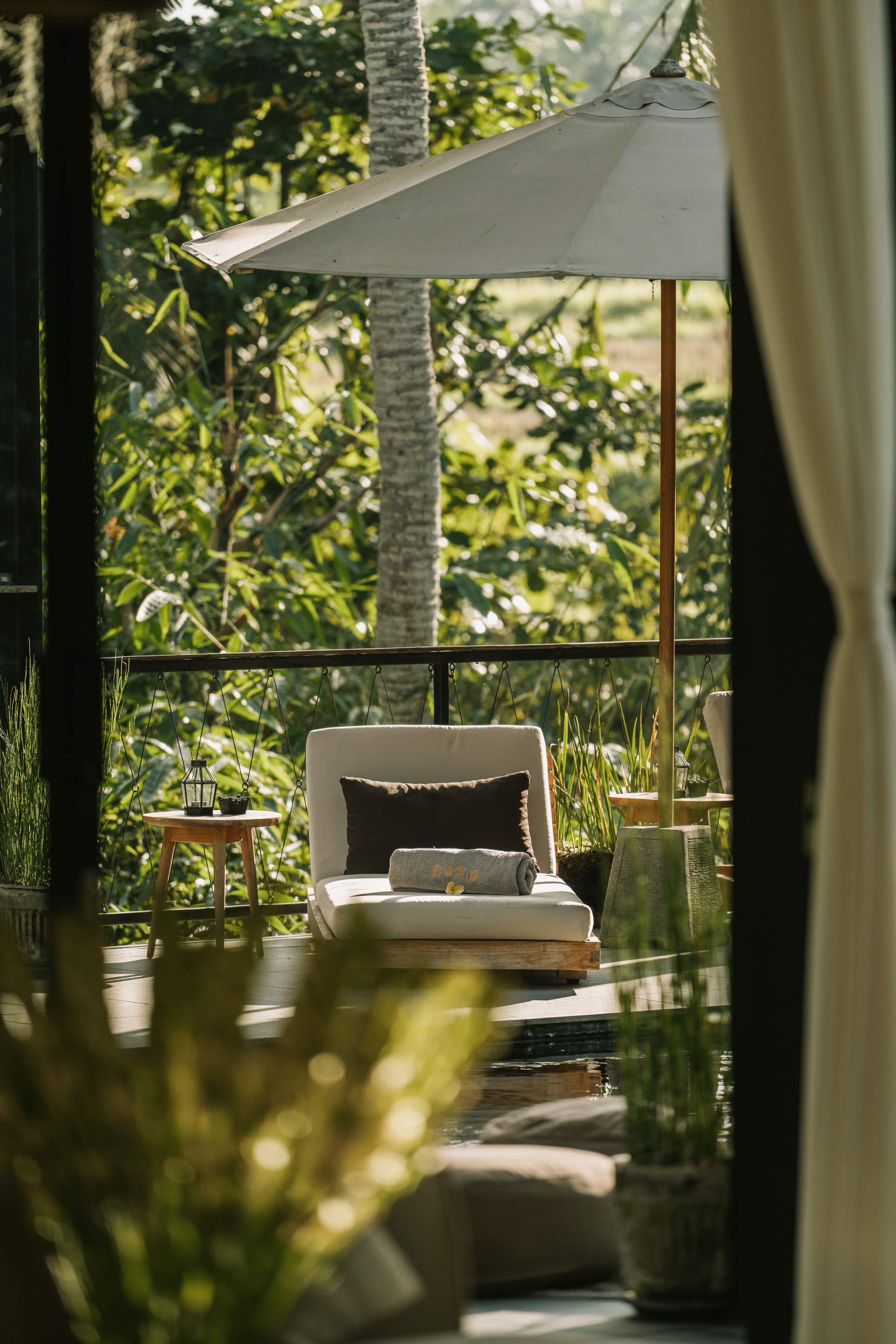 A white chair with a towel on it sits on a patio.