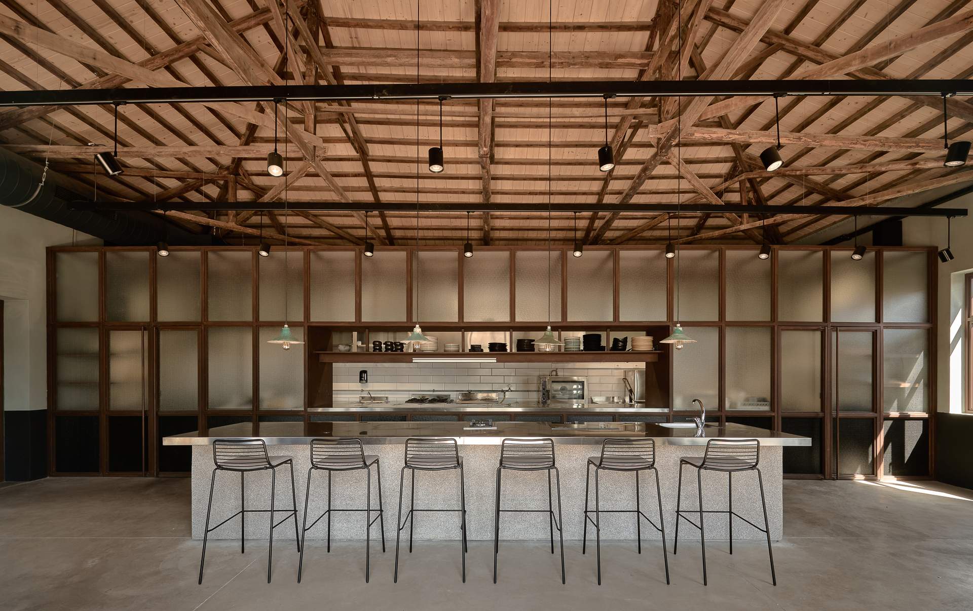 A kitchen with a counter and stools.