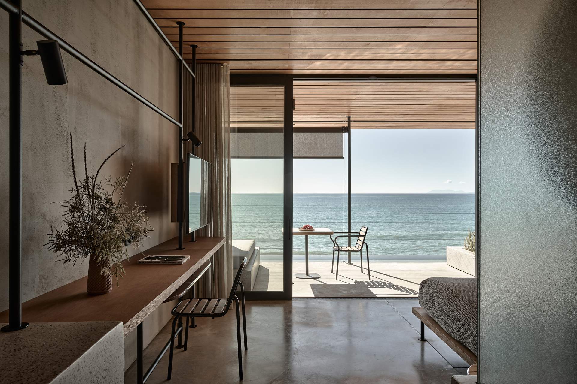 A living room with a large window overlooking the ocean.