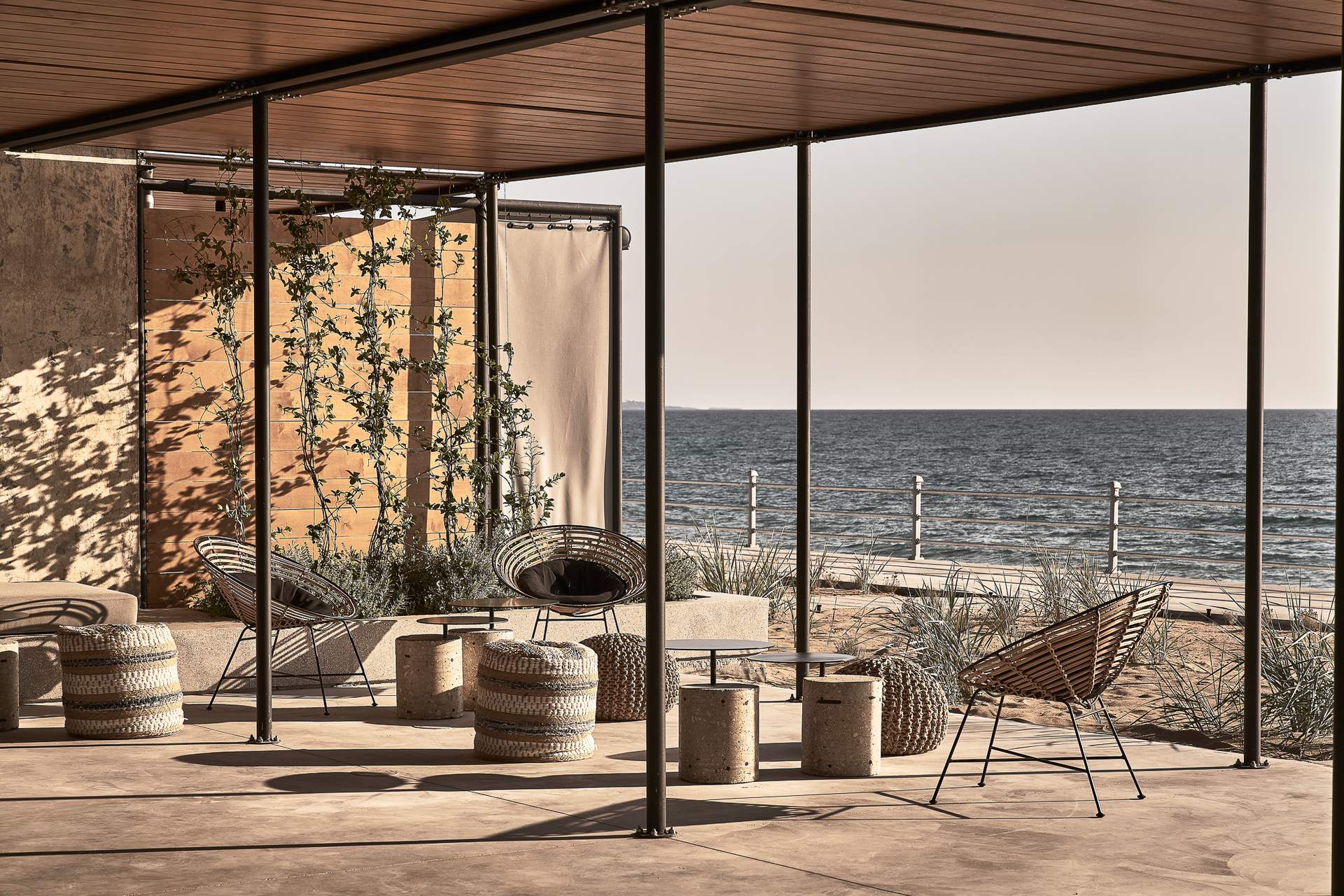 A patio with a table and chairs overlooking the ocean.