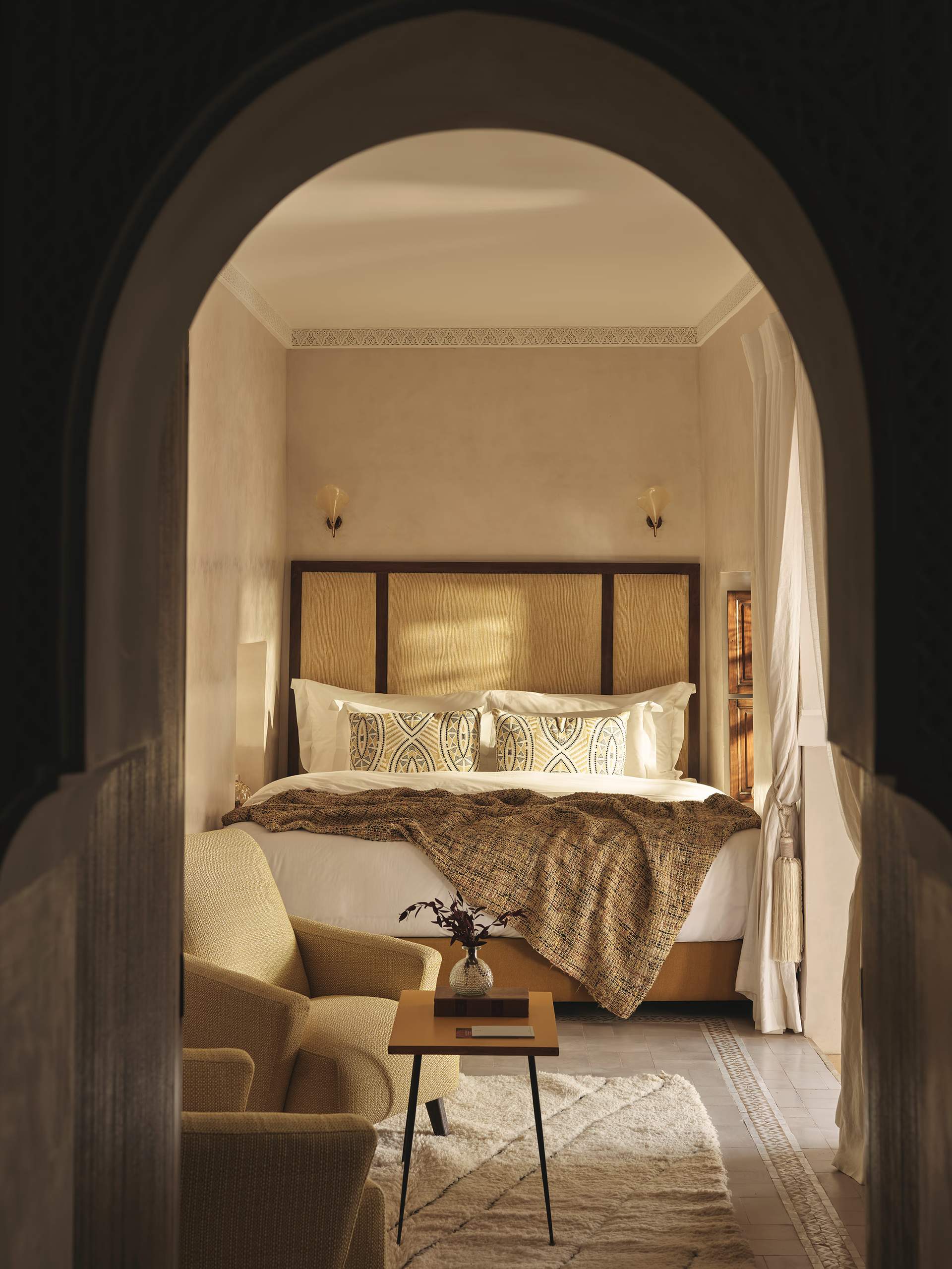 A bedroom with a bed and a chair.