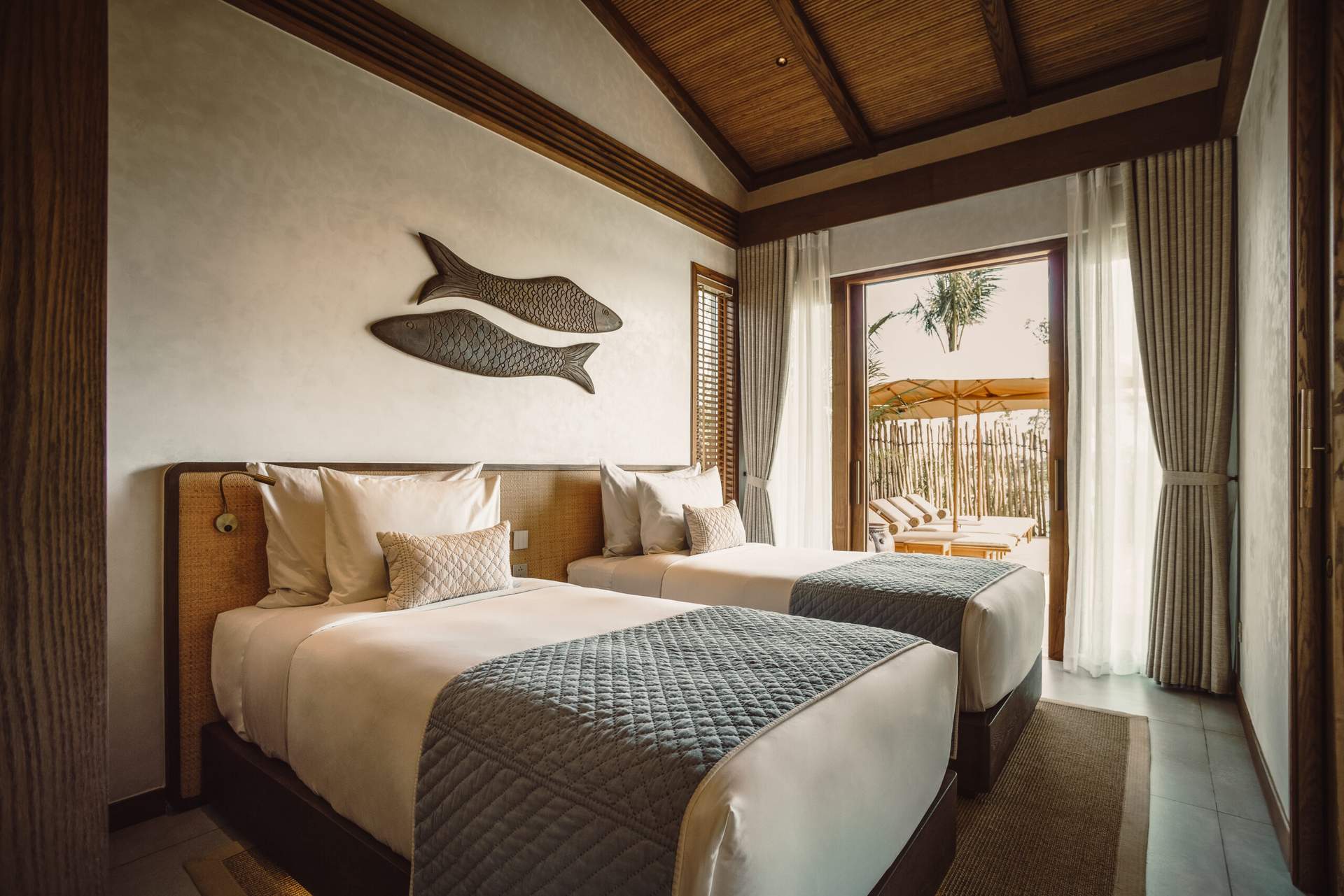 A bedroom with two beds and a fish on the wall.