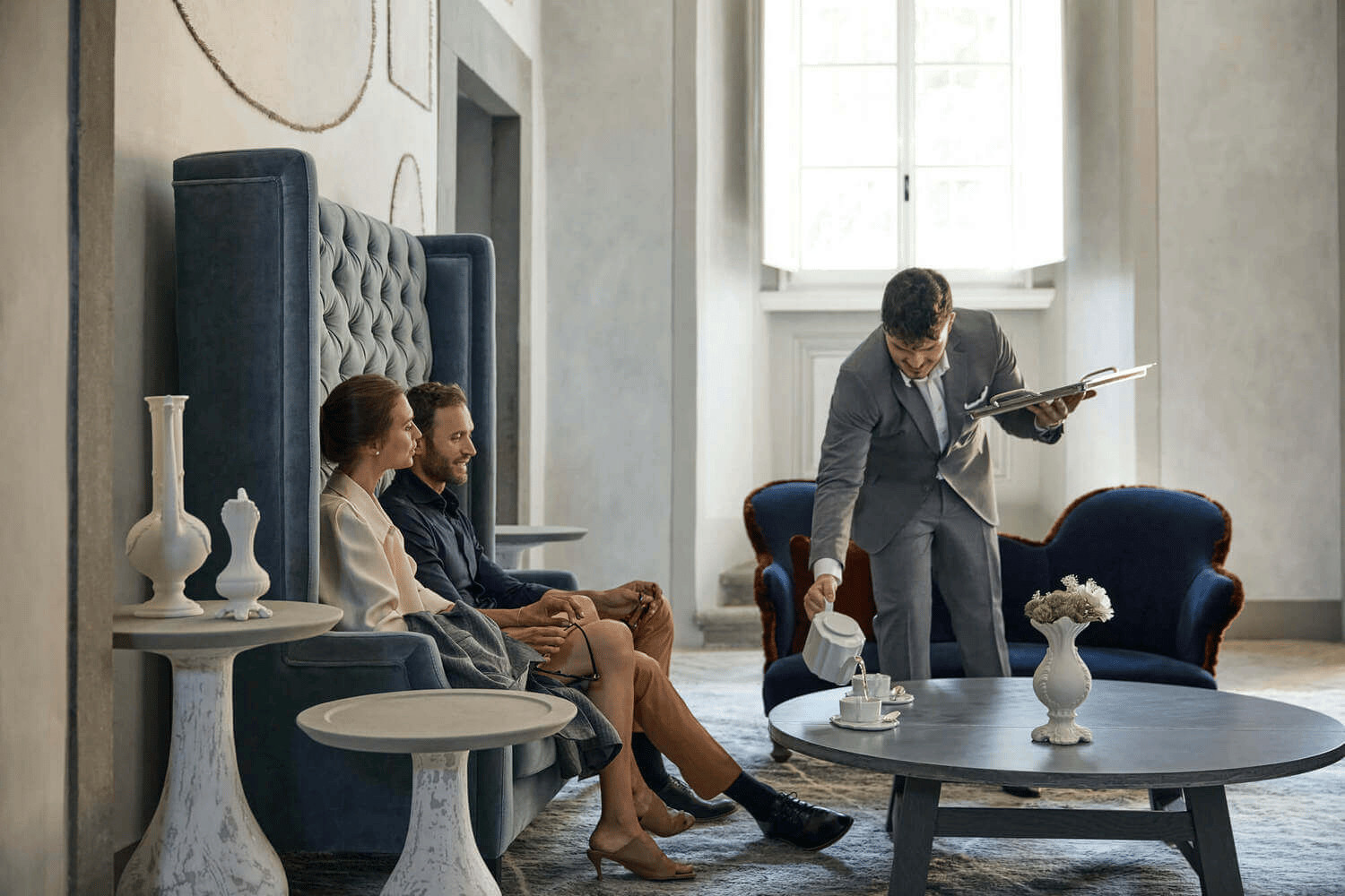 Hotel staff serving guests in an elegant lounge