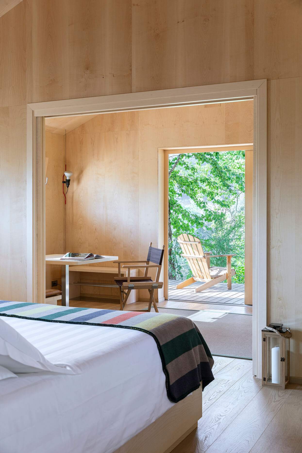 A bedroom with a bed, a chair, and a window.