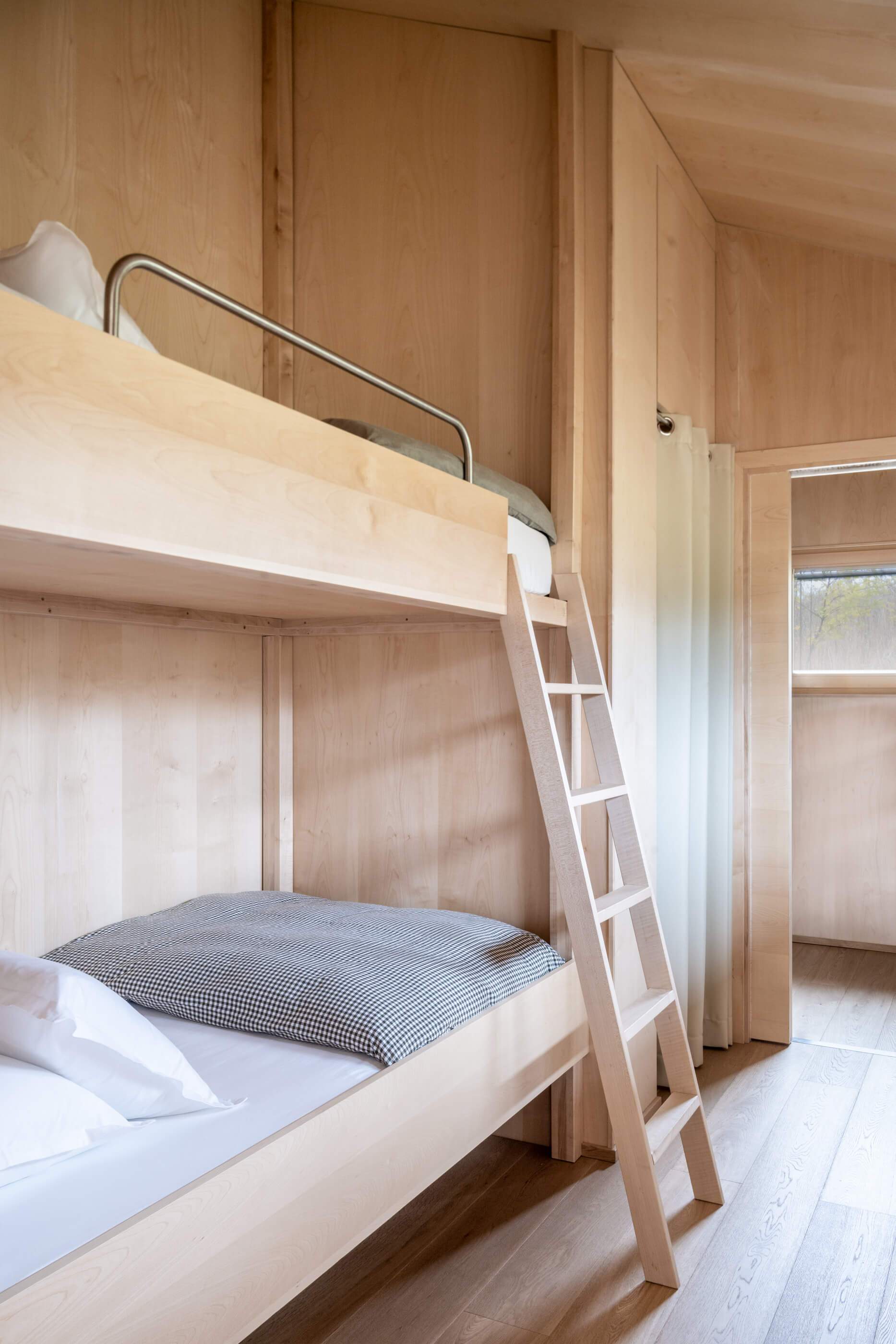 A small bedroom with a ladder leading to a loft bed.