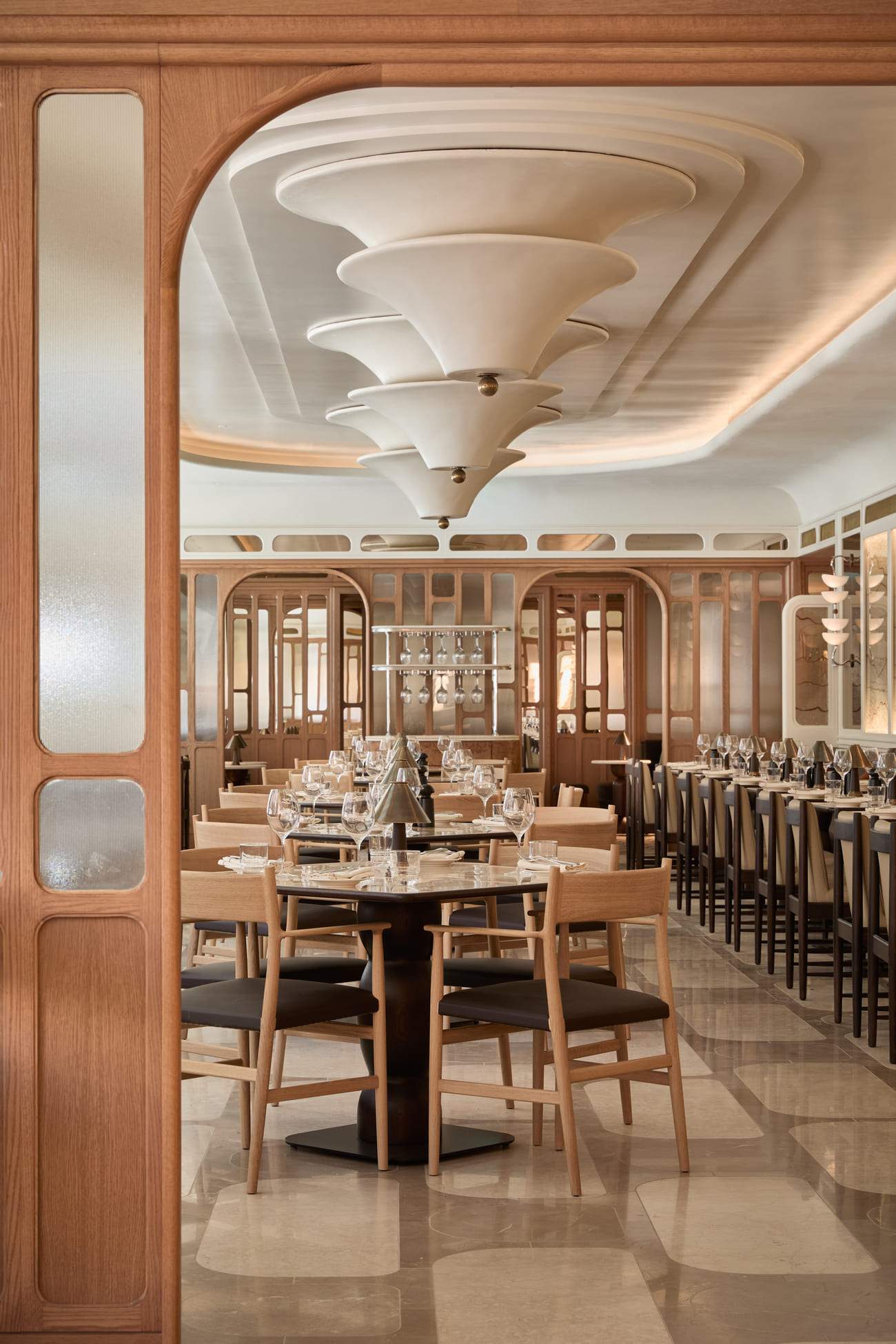 A restaurant with a large dining room and a long table with chairs.
