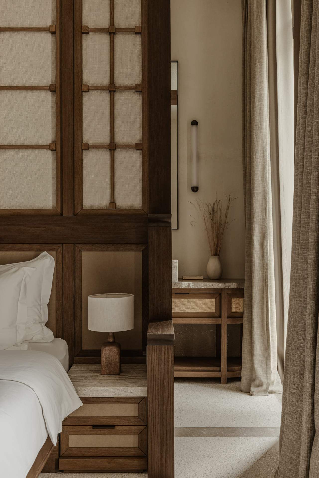 A bedroom with a bed and a lamp.