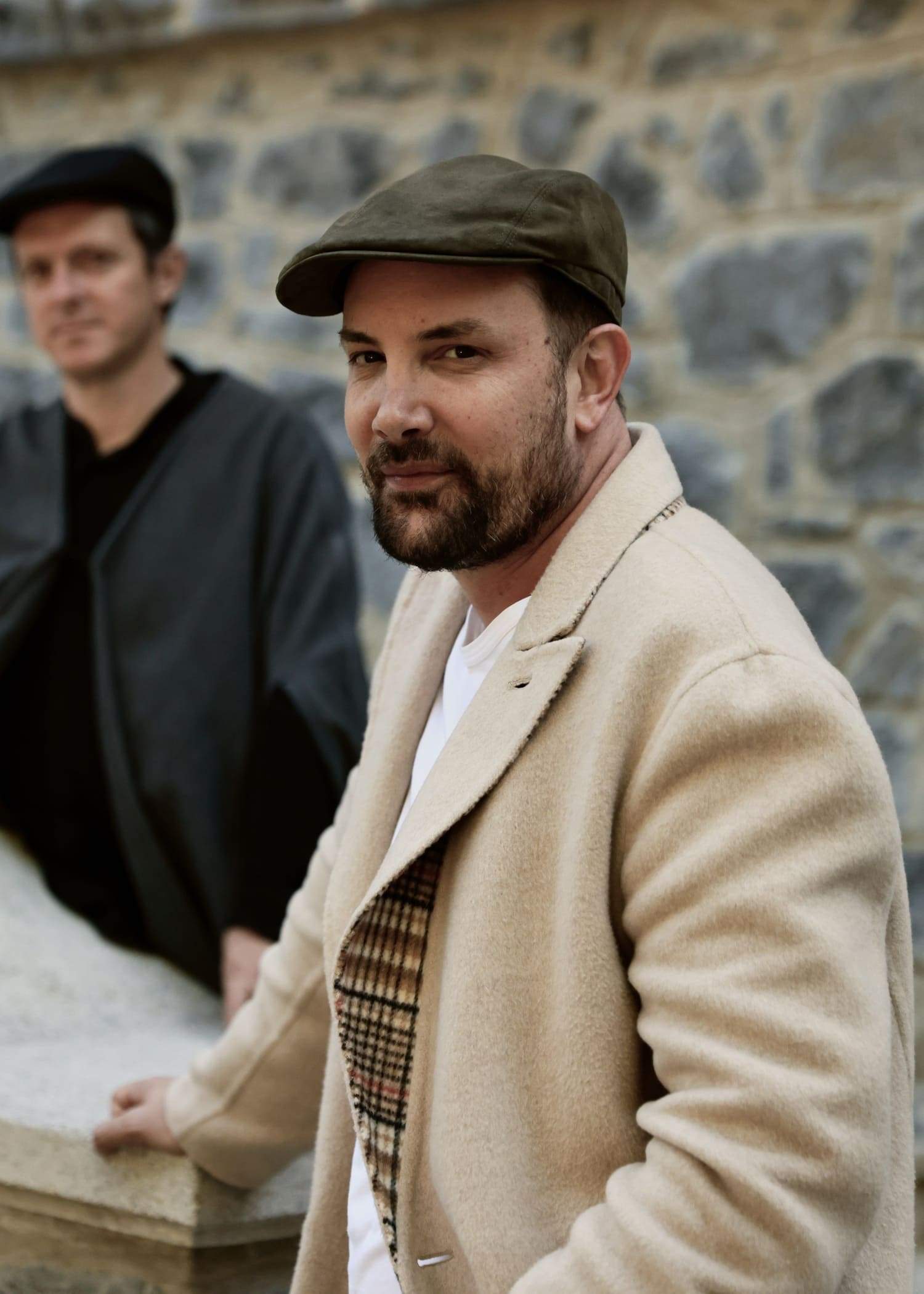 A man wearing a brown hat and a brown jacket.